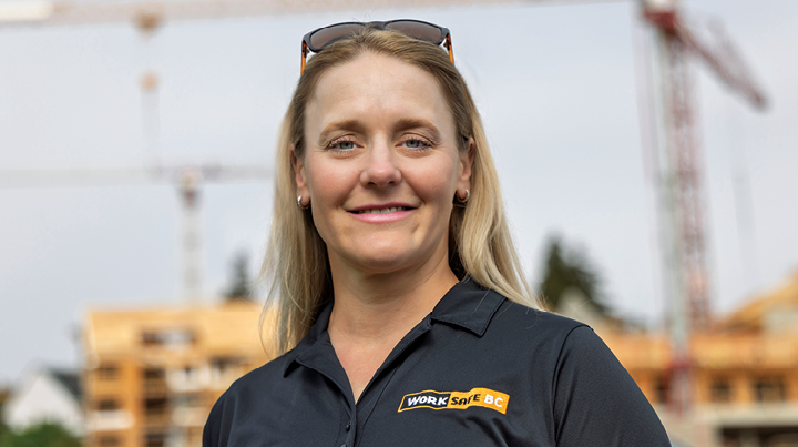 A Work Safe BC worker with a blurred construction site in the background