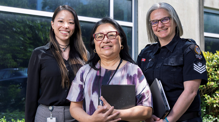 Three women working in policing smiling while posing for photo