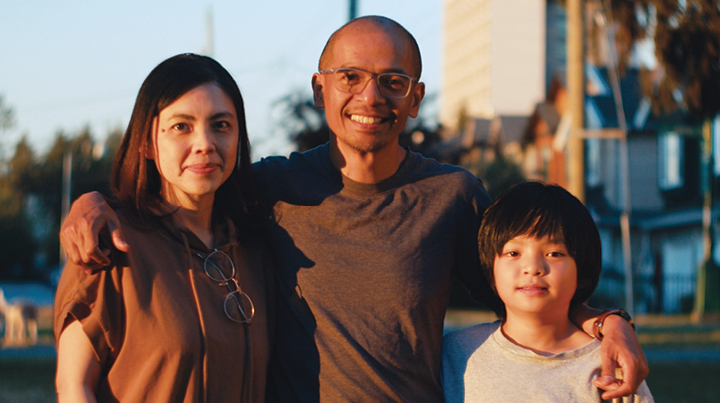 A family of three posing for a photo