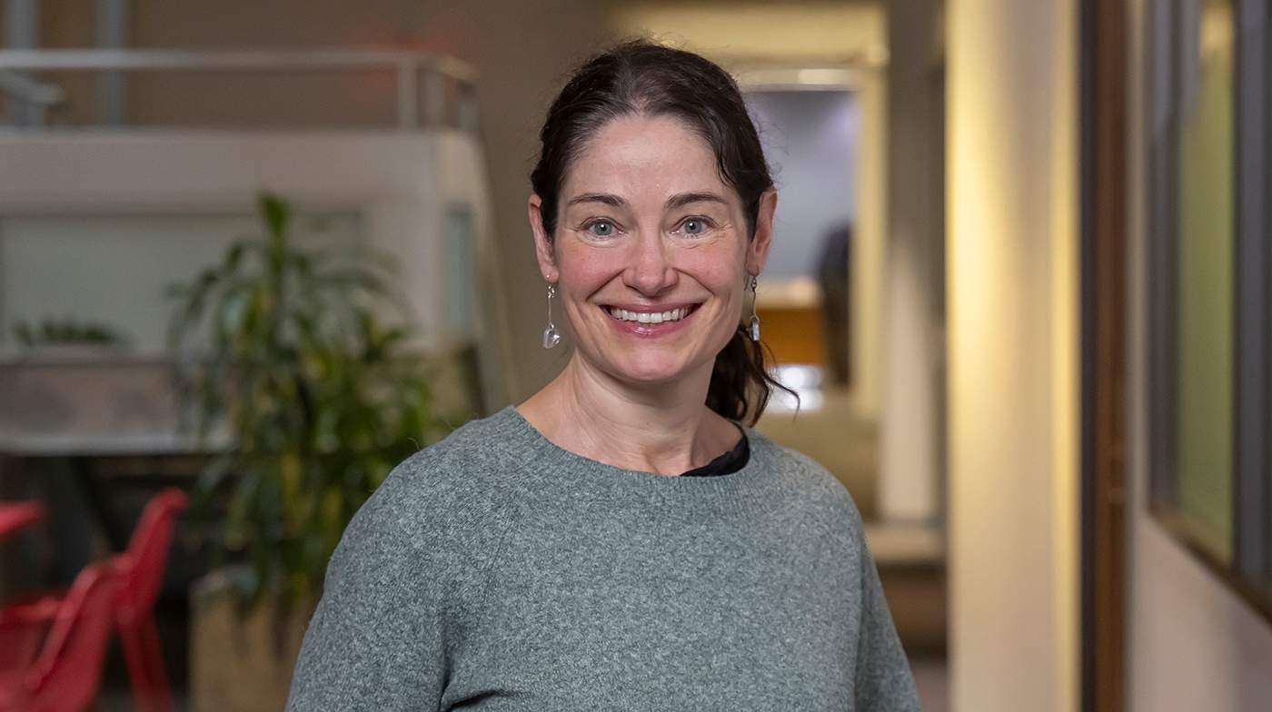 Sasha Brown, occupational audiologist at WorkSafeBC, standing in an office hallway.
